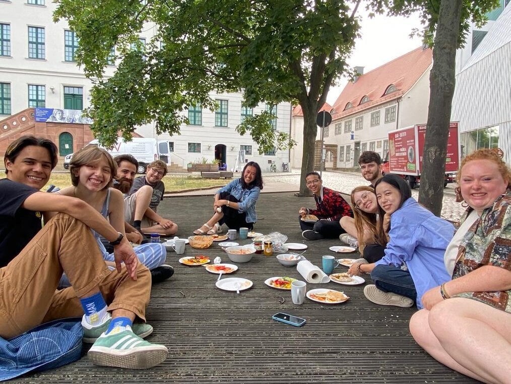 EC Germany A group of people eat a meal outside.